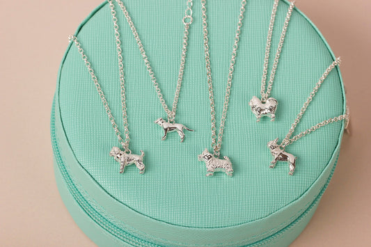 Sterling silver dog breed necklaces on a mint green jewellery box
